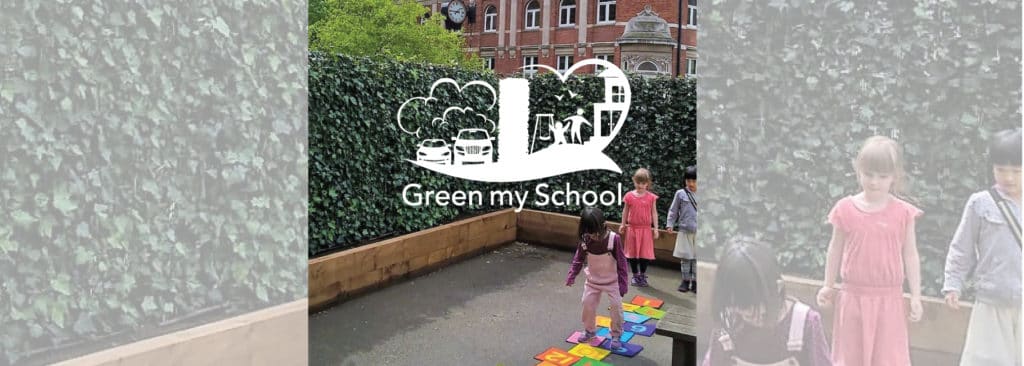 Children by an ivy hedge in timber planters with Green my School logo, St Cuthberts