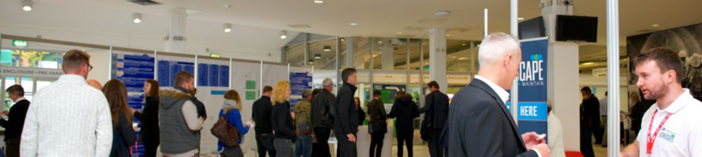 Visitors and exhibitors in an exhibition hall with a CAPE sign