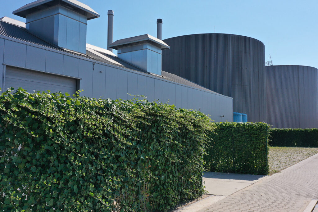 Aanzicht van de biomassacentrale van Lingezegen Energy in Bemmel met groene hagen rondom het terrein